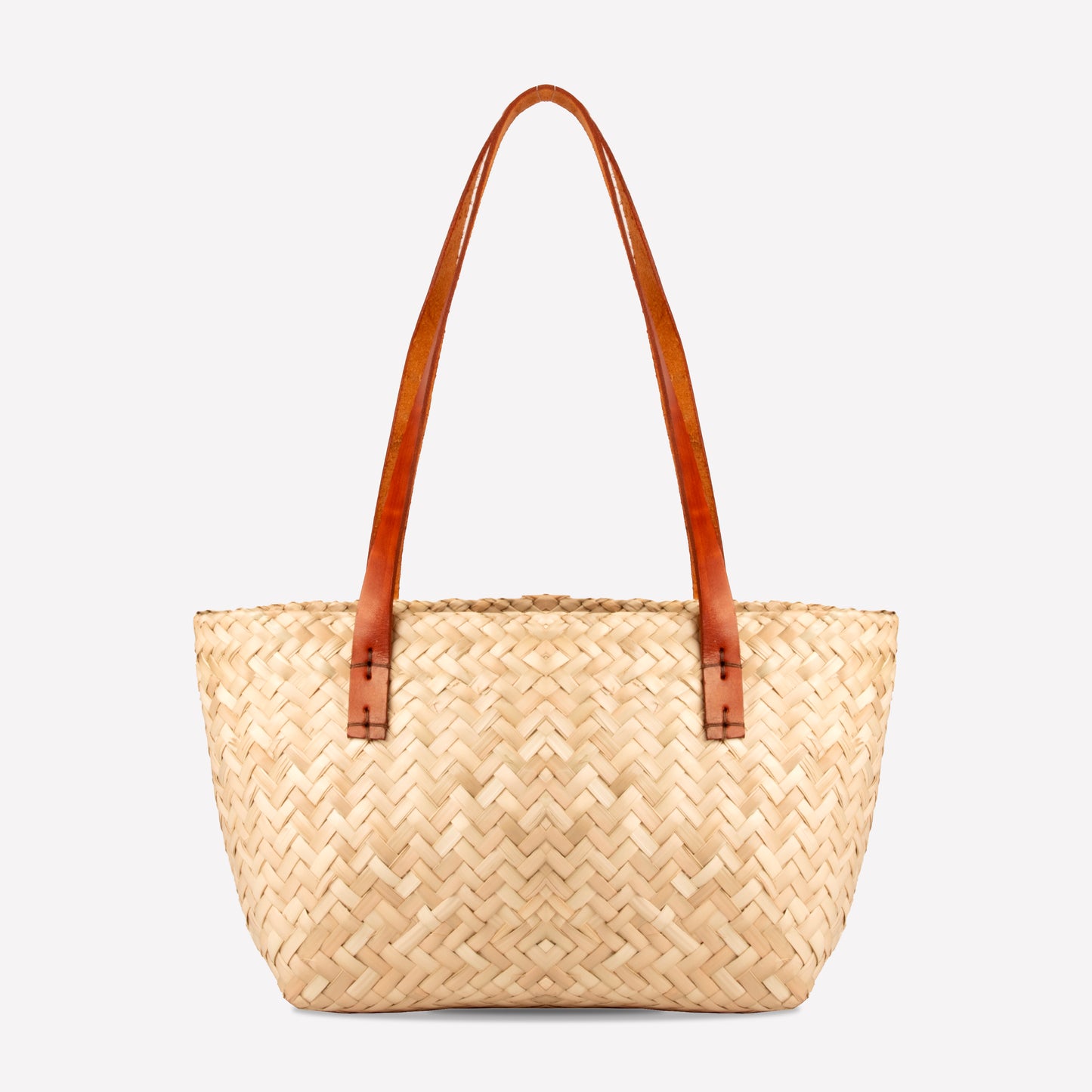 Natural woven straw handbag with brown leather handle on a white background