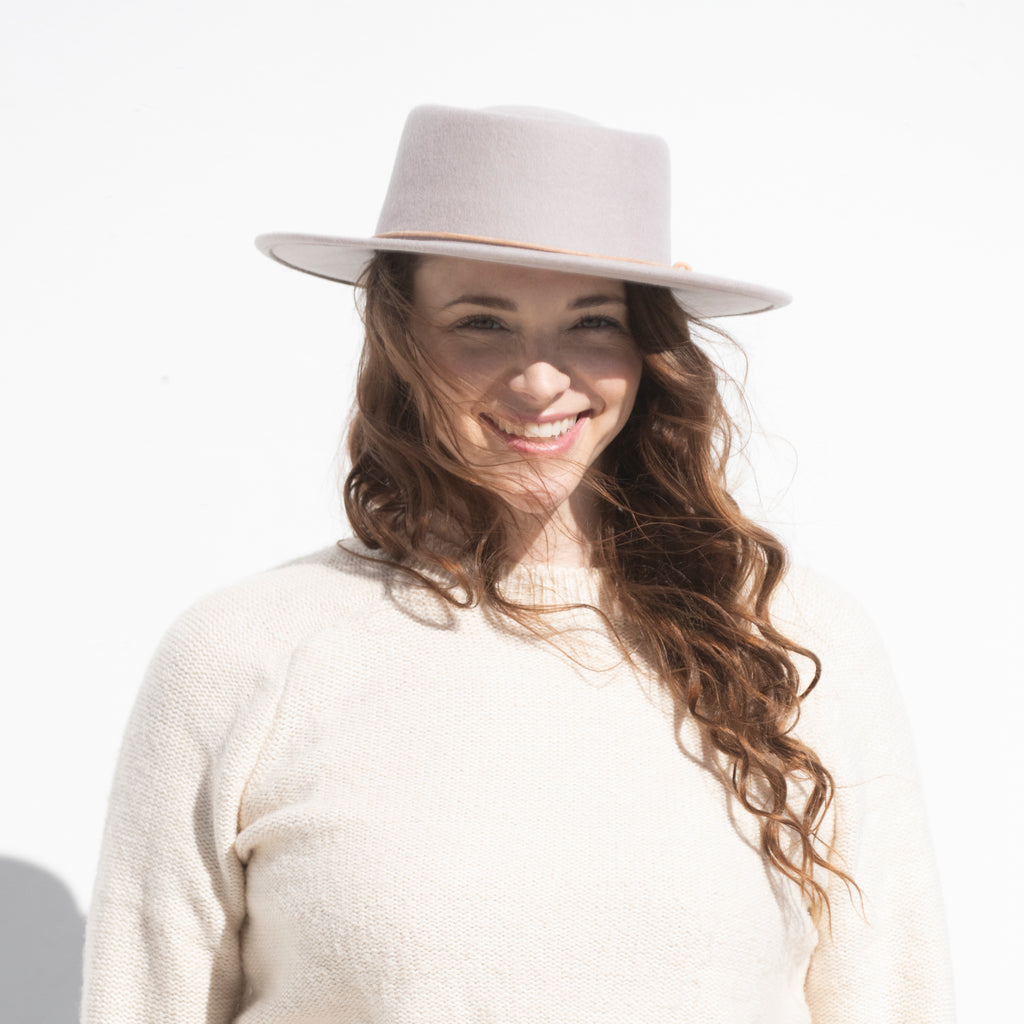 woman with brown hair wearing lavender wool hat