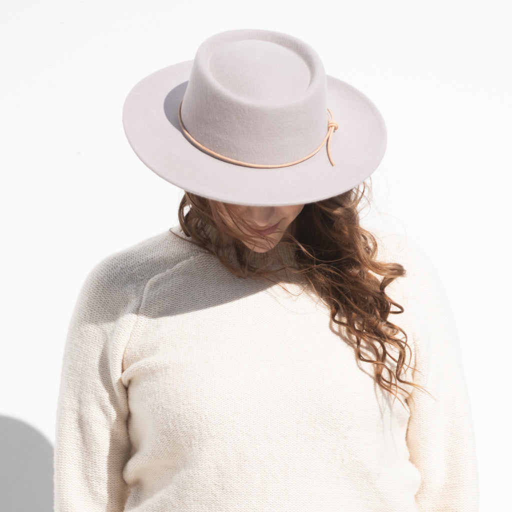 woman with brown hair wearing lavender wool hat